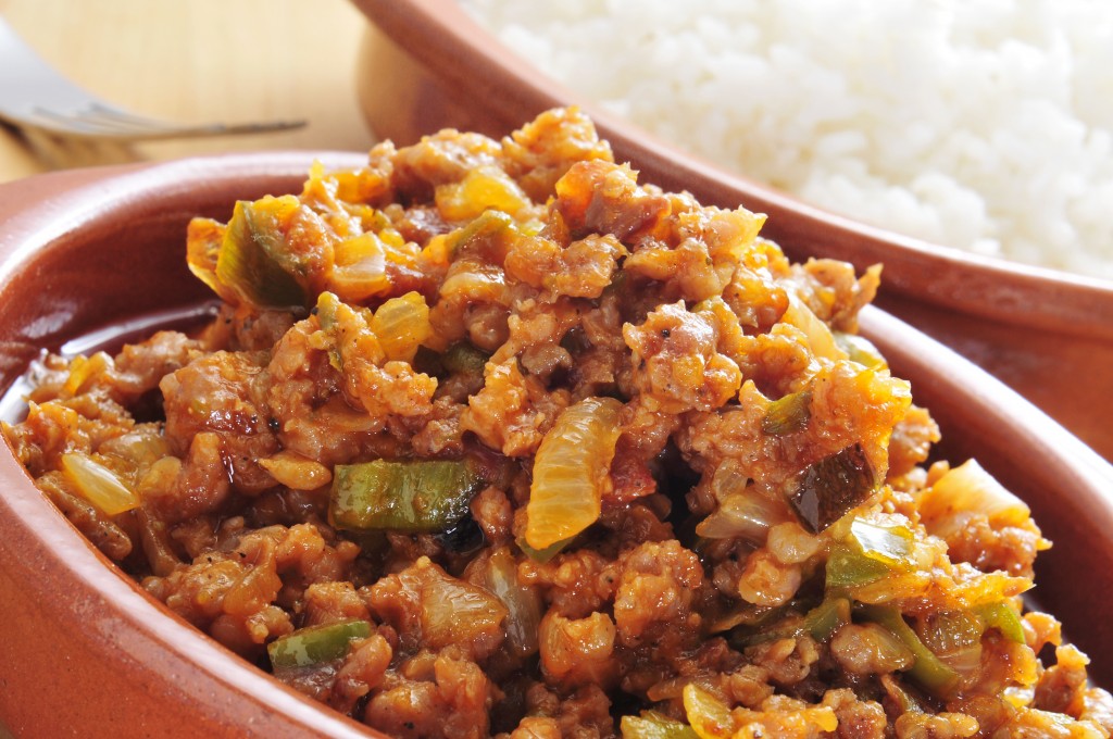 closeup of a earthenware plate with picadillo, a traditional dish in many latin american countries, served with rice